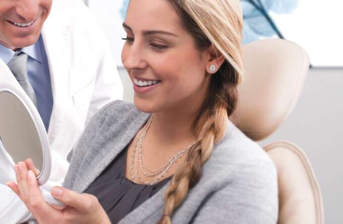 Frau begutachtet Ihr Bleaching-Ergebnis